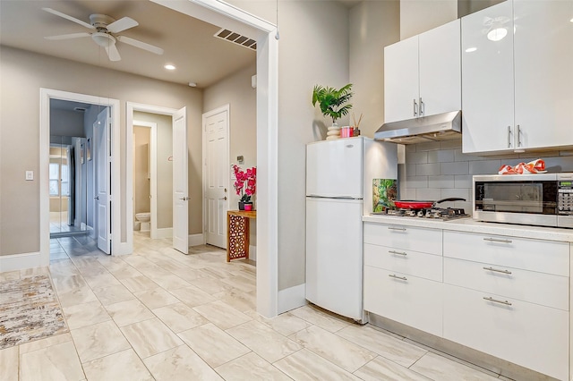 kitchen with visible vents, under cabinet range hood, light countertops, white cabinets, and appliances with stainless steel finishes