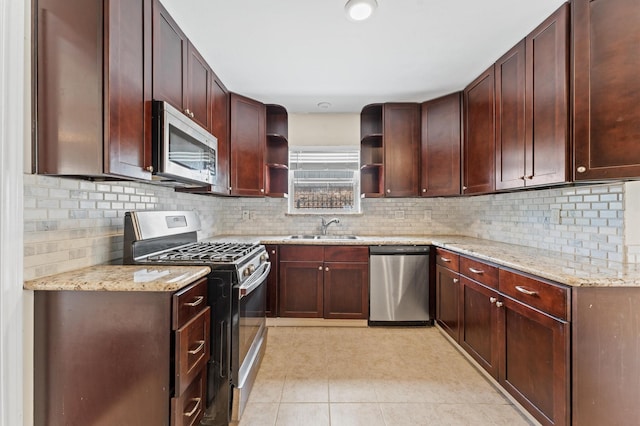kitchen with light tile patterned floors, light stone counters, a sink, open shelves, and stainless steel appliances