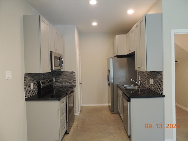 1100 Mann Rd, Conroe, TX 77303 - kitchen featuring dark countertops, stainless steel appliances, baseboards, and a sink