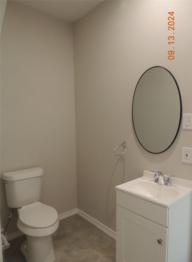 1100 Mann Rd, Conroe, TX 77303 - half bathroom featuring vanity, toilet, and baseboards