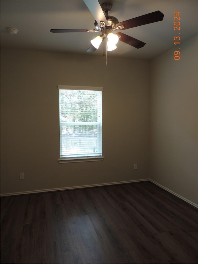 1100 Mann Rd, Conroe, TX 77303 - empty room featuring baseboards, dark wood-style flooring, and ceiling fan