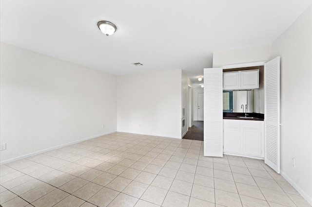 10001 Westpark Dr Unit 7, Houston, TX 77042 - empty room featuring light tile patterned floors, baseboards, visible vents, and a sink