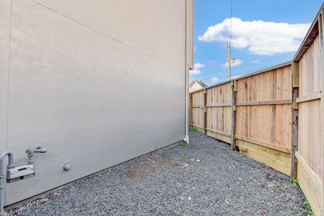 view of side of property featuring stucco siding and fence