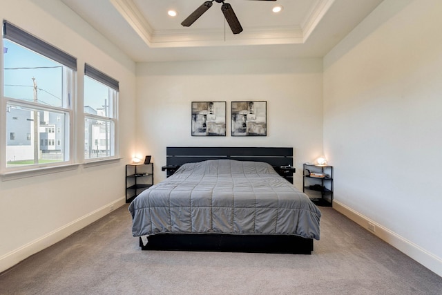 carpeted bedroom with a tray ceiling, baseboards, and ornamental molding