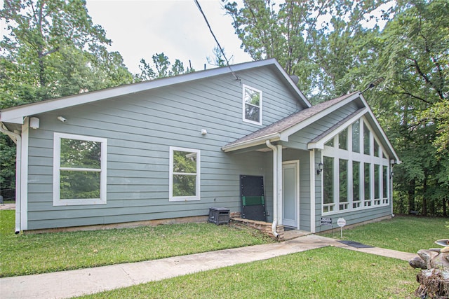 view of front facade featuring a sunroom and a front lawn