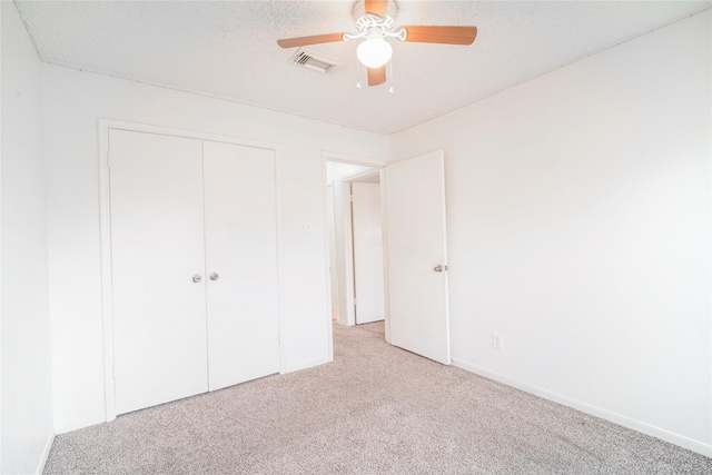 unfurnished bedroom with light colored carpet, a closet, ceiling fan, and baseboards
