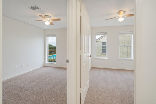 empty room featuring ceiling fan, carpet, and baseboards
