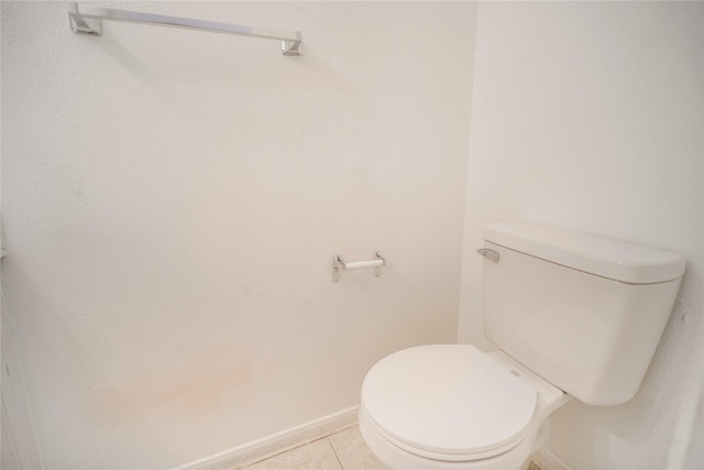 bathroom with tile patterned floors, toilet, and baseboards