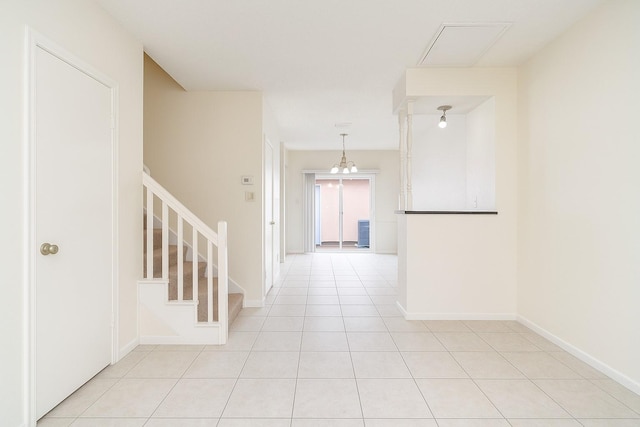 hall with stairs, baseboards, and light tile patterned floors