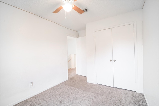 unfurnished bedroom with carpet, a closet, and baseboards
