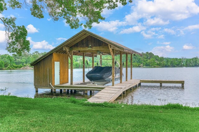 15050 Lake Paula Dr, Willis, TX 77318 - dock area with boat lift, a water view, and a lawn