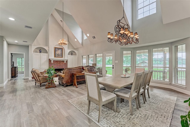 15050 Lake Paula Dr, Willis, TX 77318 - dining space featuring high vaulted ceiling, a chandelier, baseboards, a fireplace, and light wood-style floors