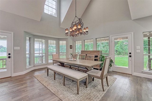 15050 Lake Paula Dr, Willis, TX 77318 - dining room with high vaulted ceiling, a chandelier, baseboards, and light wood-style flooring