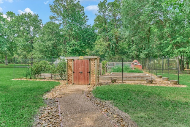 15050 Lake Paula Dr, Willis, TX 77318 - view of yard with a vegetable garden, a storage unit, and an outbuilding