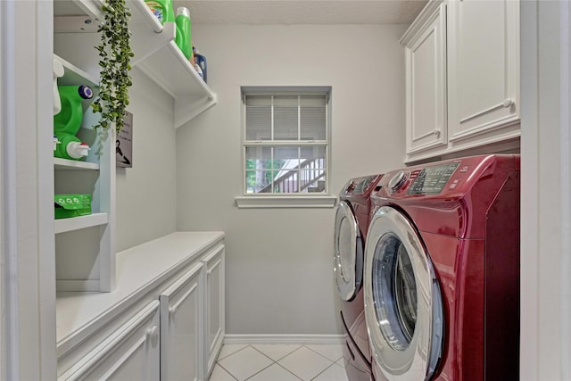 15050 Lake Paula Dr, Willis, TX 77318 - laundry room featuring washer and dryer, cabinet space, light tile patterned floors, and baseboards