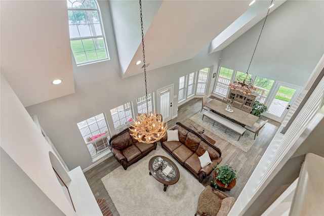 15050 Lake Paula Dr, Willis, TX 77318 - living room featuring a towering ceiling, a chandelier, wood finished floors, healthy amount of natural light, and recessed lighting