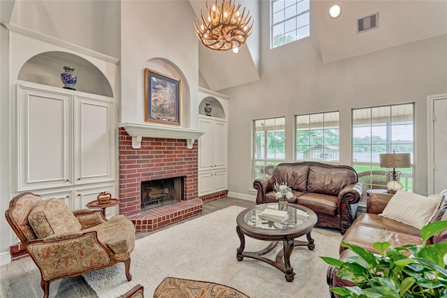 15050 Lake Paula Dr, Willis, TX 77318 - living area featuring a towering ceiling, baseboards, wood finished floors, a brick fireplace, and a chandelier