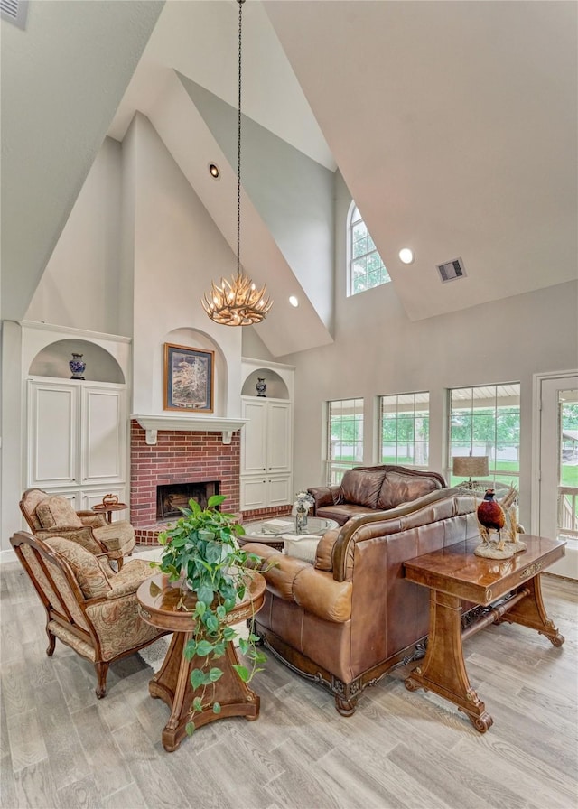 15050 Lake Paula Dr, Willis, TX 77318 - living area with high vaulted ceiling, light wood-style floors, healthy amount of natural light, a fireplace, and a chandelier