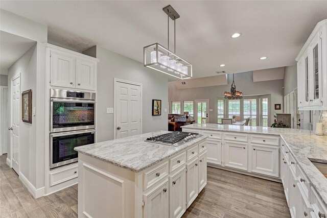 15050 Lake Paula Dr, Willis, TX 77318 - kitchen featuring appliances with stainless steel finishes, white cabinetry, a chandelier, light wood-type flooring, and recessed lighting