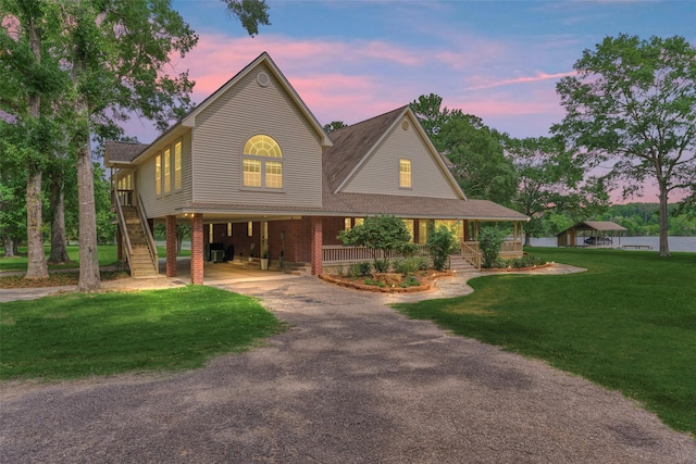 15050 Lake Paula Dr, Willis, TX 77318 - view of front of property with a carport, driveway, a front yard, a porch, and stairs