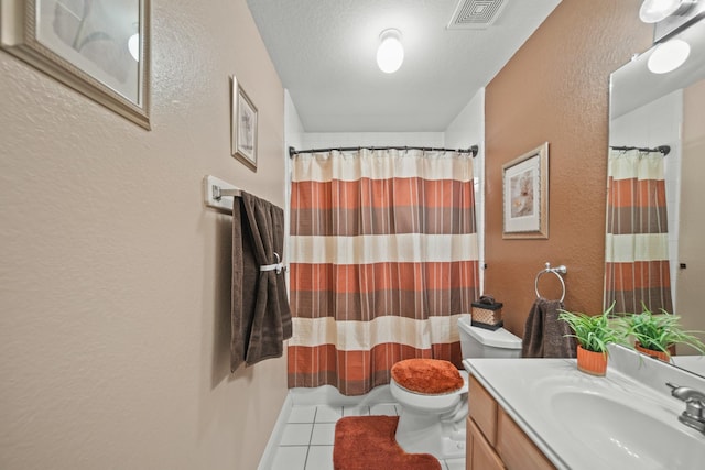 bathroom with toilet, visible vents, tile patterned flooring, vanity, and a textured wall