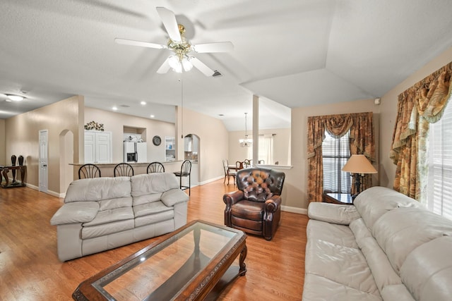 living area with ceiling fan, baseboards, light wood-style flooring, and arched walkways