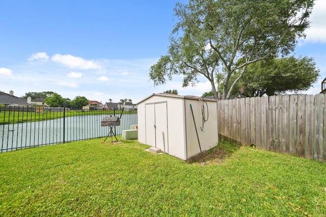 view of shed featuring a water view and a fenced backyard