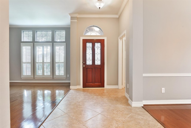 tiled entryway featuring baseboards and ornamental molding