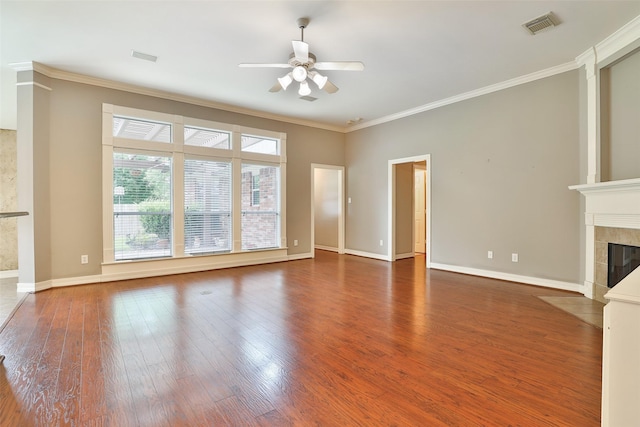 unfurnished living room with ornamental molding, wood finished floors, a fireplace, and ceiling fan