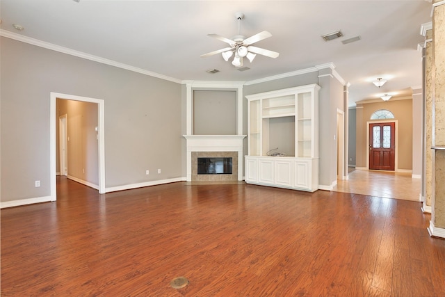 unfurnished living room with a tiled fireplace, crown molding, visible vents, baseboards, and ceiling fan