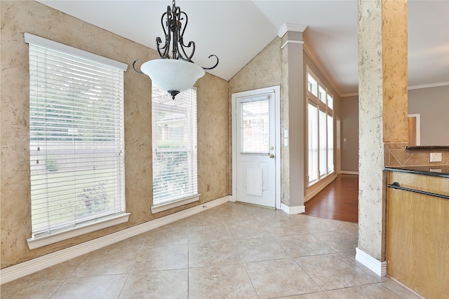 unfurnished dining area featuring a notable chandelier, crown molding, baseboards, lofted ceiling, and light tile patterned flooring