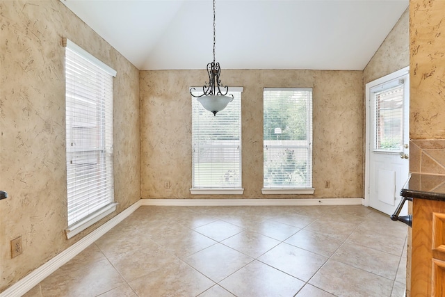 unfurnished dining area with lofted ceiling, baseboards, and light tile patterned flooring