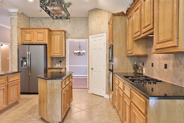 kitchen with stovetop with downdraft, oven, stainless steel fridge, light tile patterned floors, and a kitchen island