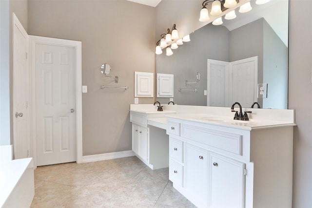 bathroom with tile patterned flooring, an inviting chandelier, double vanity, and a sink