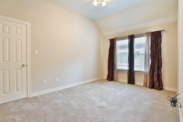 carpeted empty room with lofted ceiling and baseboards