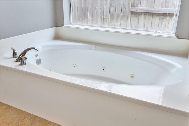 bathroom featuring a tub with jets and tile patterned flooring