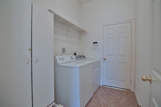laundry area with washing machine and clothes dryer, laundry area, and light tile patterned floors