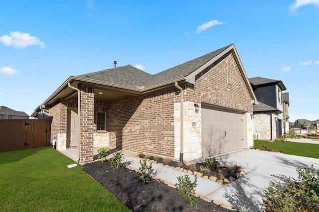 view of side of property featuring a yard, brick siding, roof with shingles, and a garage