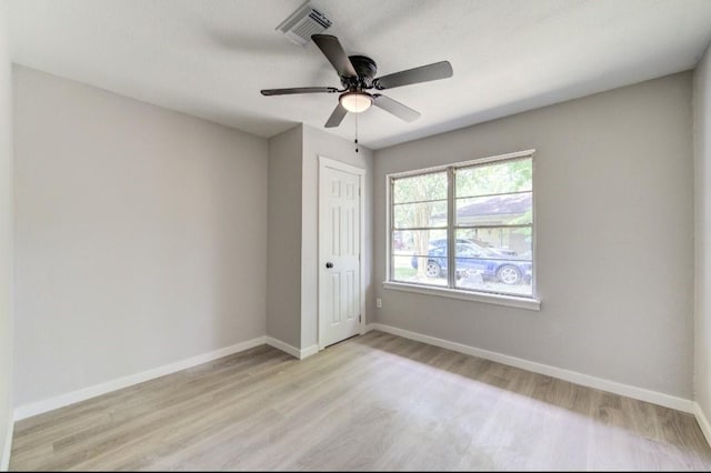 unfurnished bedroom featuring a closet, light wood-type flooring, visible vents, ceiling fan, and baseboards