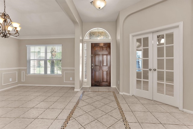 18239 Rustic Springs Dr, Tomball, TX 77375 - entryway featuring light tile patterned flooring, a chandelier, arched walkways, ornamental molding, and french doors
