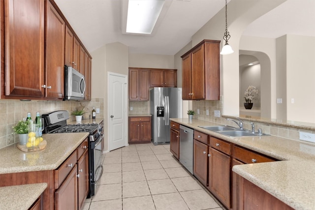 18239 Rustic Springs Dr, Tomball, TX 77375 - kitchen with stainless steel appliances, a sink, light tile patterned floors, arched walkways, and backsplash