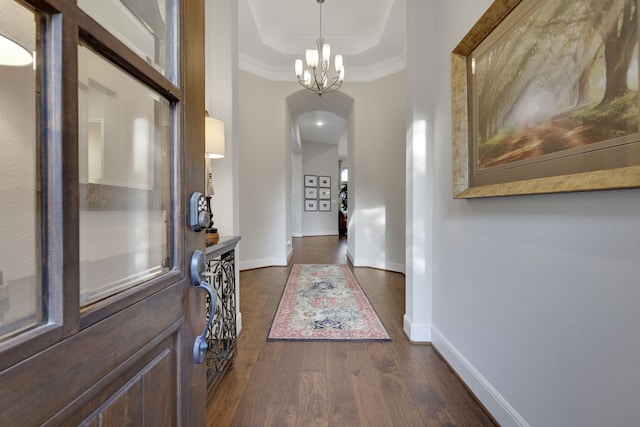 1614 Primrose Ln, Katy, TX 77493 - entrance foyer with arched walkways, baseboards, a chandelier, dark wood-style flooring, and a raised ceiling