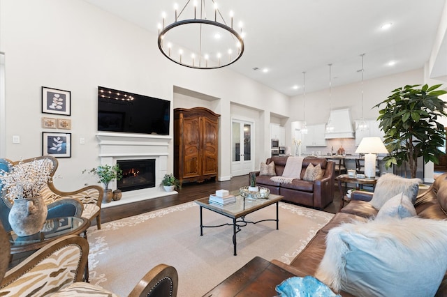 1614 Primrose Ln, Katy, TX 77493 - living area featuring wood finished floors, a lit fireplace, a chandelier, recessed lighting, and a high ceiling