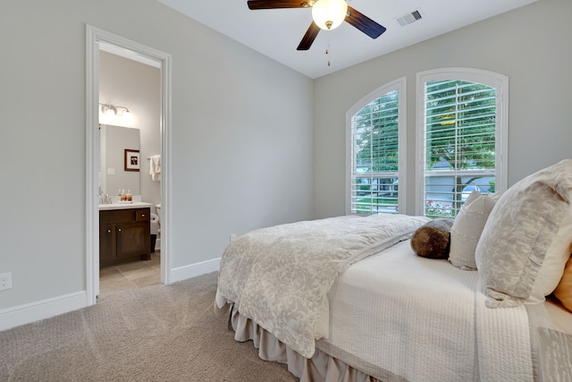 1614 Primrose Ln, Katy, TX 77493 - bedroom with light colored carpet, baseboards, ensuite bath, and a ceiling fan