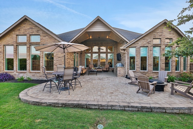 1614 Primrose Ln, Katy, TX 77493 - rear view of property featuring brick siding, an outdoor fire pit, a patio, and a lawn