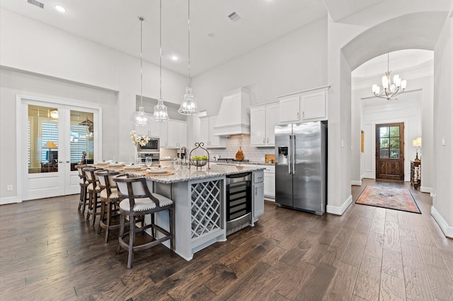 1614 Primrose Ln, Katy, TX 77493 - kitchen featuring stainless steel appliances, beverage cooler, white cabinetry, premium range hood, and recessed lighting