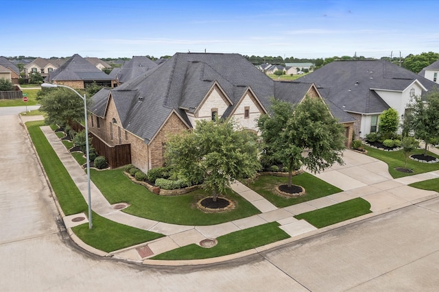 1614 Primrose Ln, Katy, TX 77493 - view of front of house with a residential view, concrete driveway, a front lawn, and brick siding
