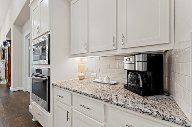 1614 Primrose Ln, Katy, TX 77493 - kitchen with appliances with stainless steel finishes, white cabinetry, decorative backsplash, and light stone counters