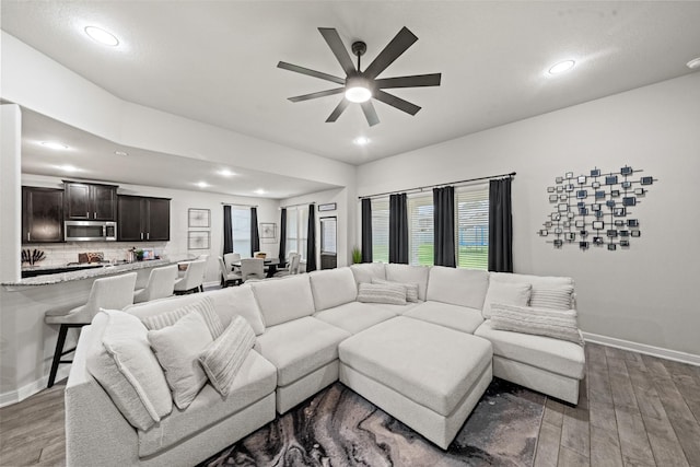 living area featuring recessed lighting, baseboards, a ceiling fan, and wood finished floors