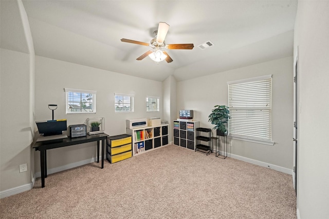 carpeted home office with ceiling fan, lofted ceiling, baseboards, and visible vents